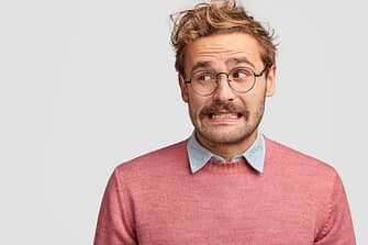 puzzled-attractive-bearded-emotive-man-wonk-spectacles-looks-with-worried-embarrassed-expression-aside_273609-16699