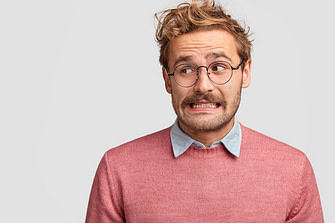 puzzled-attractive-bearded-emotive-man-wonk-spectacles-looks-with-worried-embarrassed-expression-aside_273609-16699